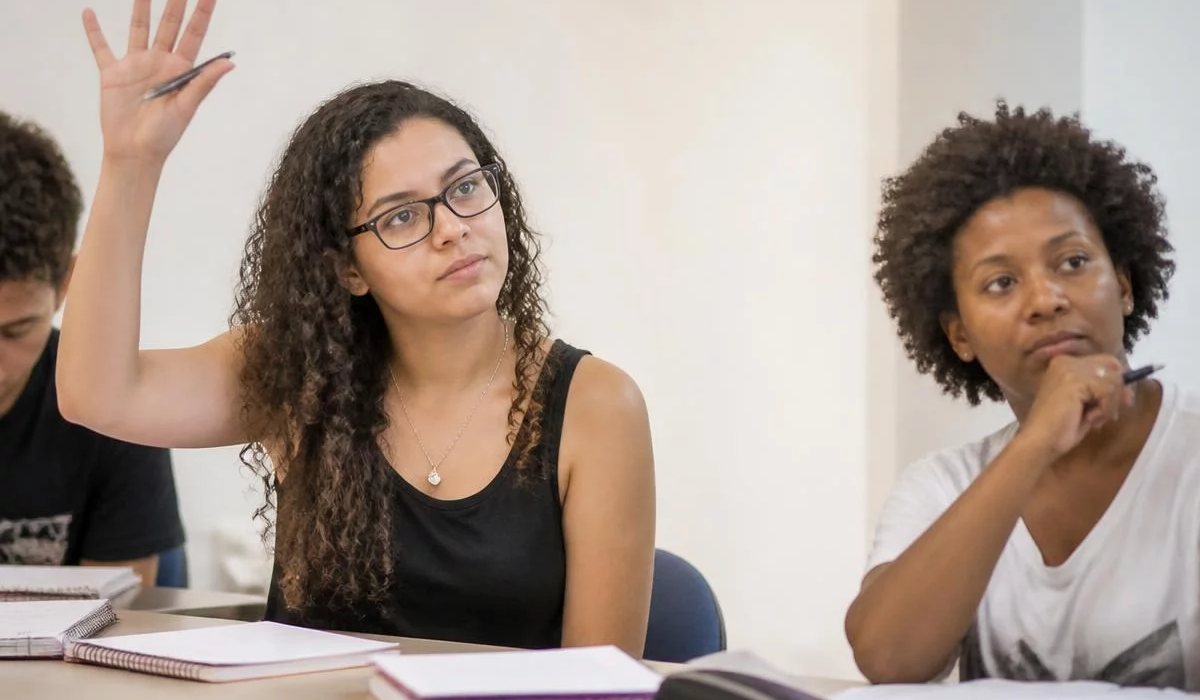 Duas pessoas preparando a próxima rodada com caderno e marca-texto na mão